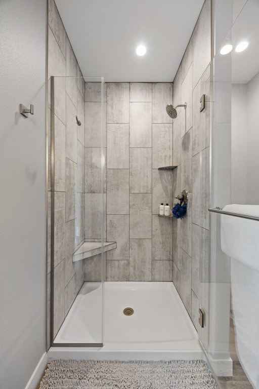 bathroom with baseboards, recessed lighting, toilet, and a shower stall