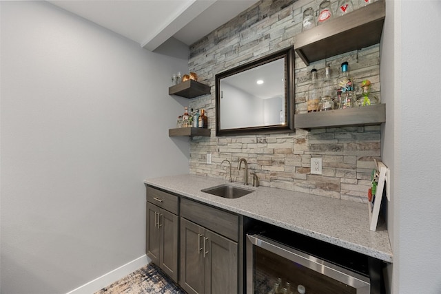bar with a sink, indoor wet bar, baseboards, decorative backsplash, and wine cooler