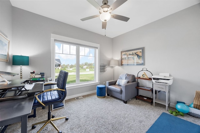 carpeted office space featuring baseboards, a ceiling fan, and visible vents