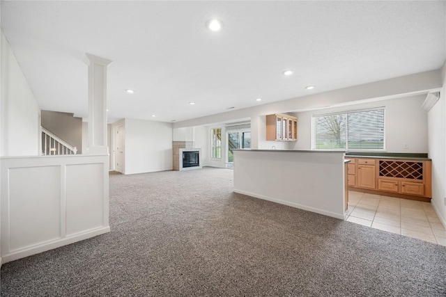 unfurnished living room featuring recessed lighting, light tile patterned floors, light carpet, and a tile fireplace
