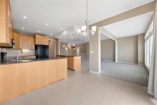 kitchen featuring freestanding refrigerator, a peninsula, open floor plan, and light colored carpet