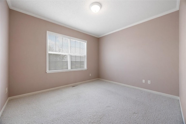 carpeted empty room featuring crown molding and baseboards