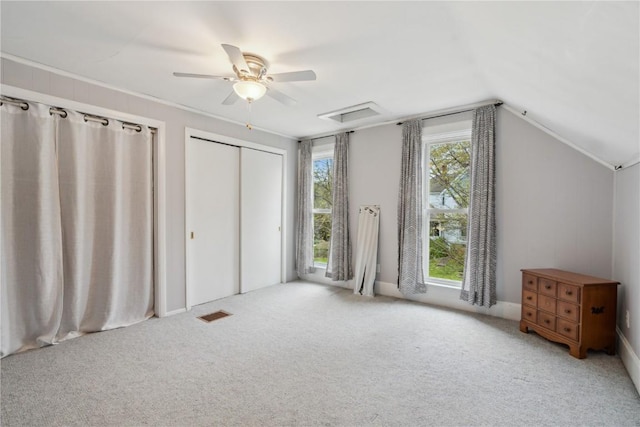 unfurnished bedroom featuring vaulted ceiling, carpet floors, a ceiling fan, and visible vents