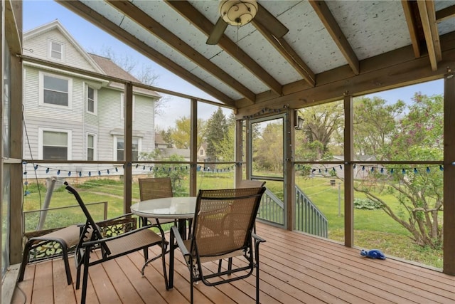 sunroom with outdoor dining area, ceiling fan, and beam ceiling