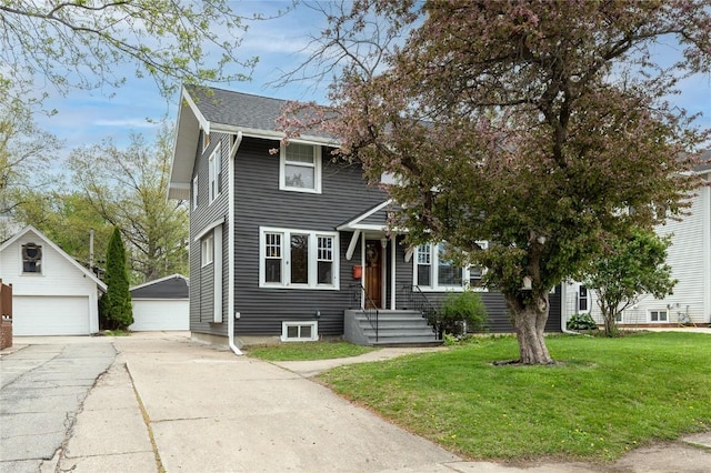 view of front of house featuring an outbuilding, a front yard, and a garage