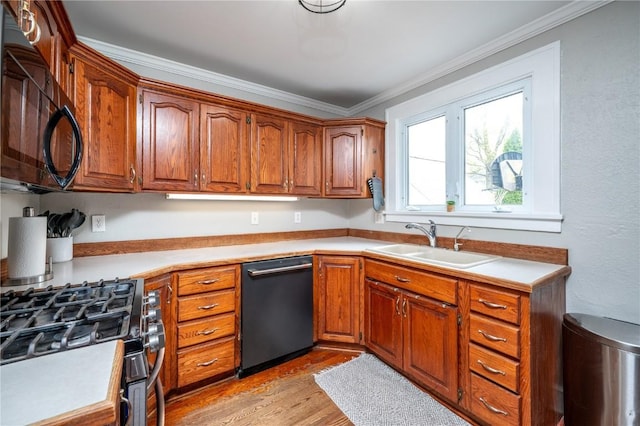 kitchen with black microwave, a sink, dishwasher, light countertops, and brown cabinetry