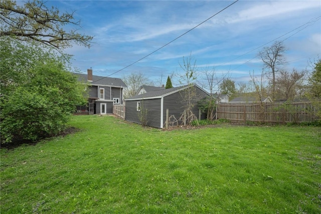 view of yard featuring fence, a storage unit, and an outdoor structure