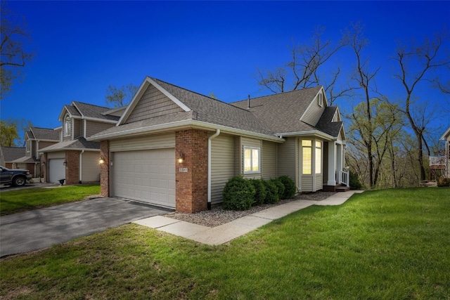 view of front of property with aphalt driveway, a shingled roof, a front yard, and a garage