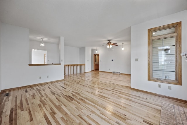 unfurnished living room featuring visible vents, light wood finished floors, ceiling fan, and baseboards