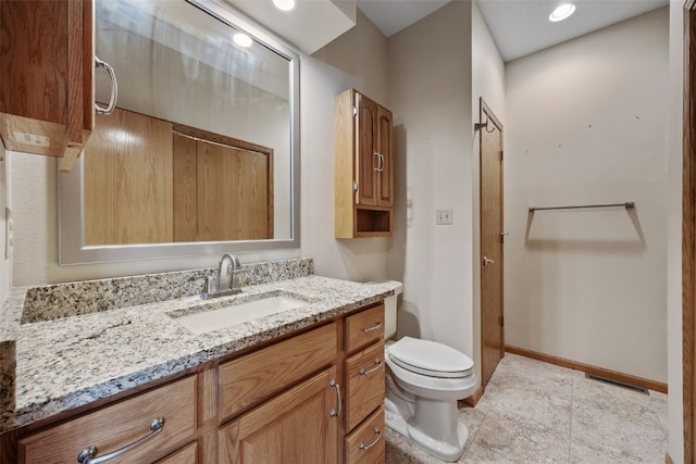 bathroom with vanity, baseboards, toilet, and visible vents