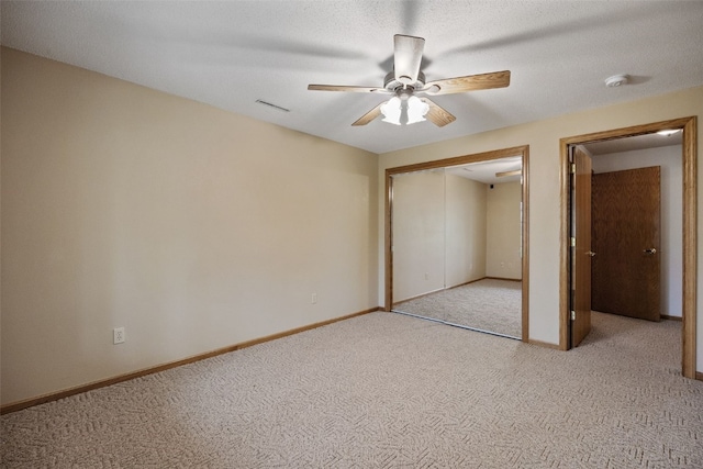 unfurnished bedroom featuring baseboards, light carpet, a closet, and visible vents