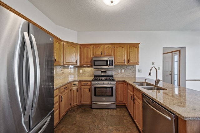 kitchen with a sink, tasteful backsplash, stainless steel appliances, and a peninsula