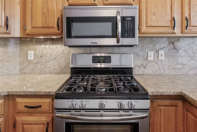 kitchen featuring light countertops, appliances with stainless steel finishes, and tasteful backsplash