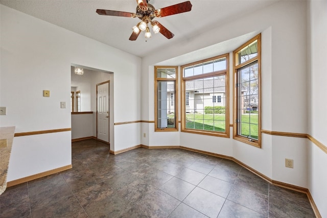unfurnished room with baseboards and ceiling fan