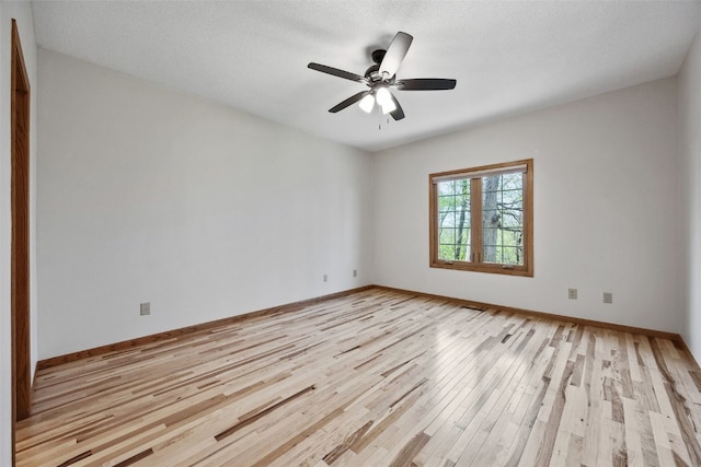 unfurnished room with light wood-style floors, baseboards, and a ceiling fan