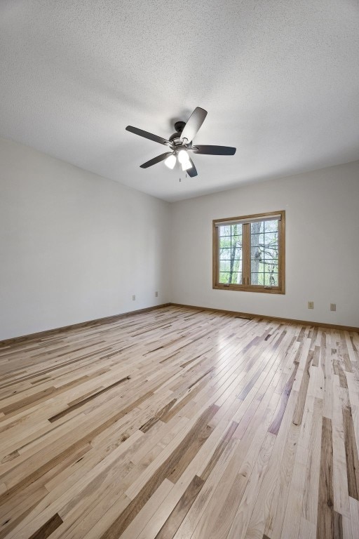 unfurnished room with a textured ceiling, ceiling fan, and light wood finished floors