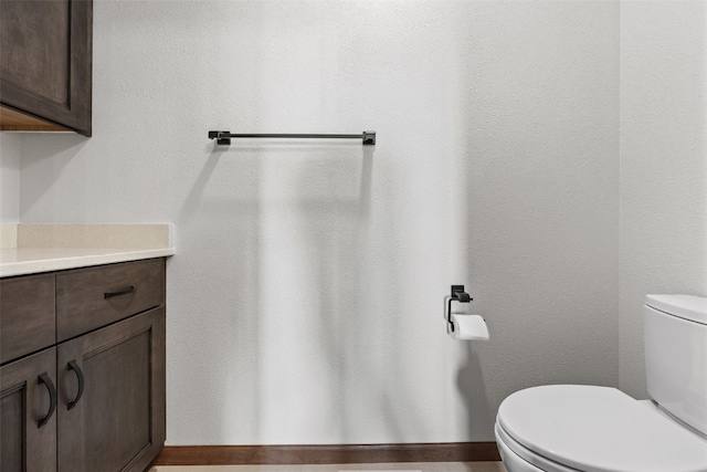 half bathroom featuring vanity and toilet