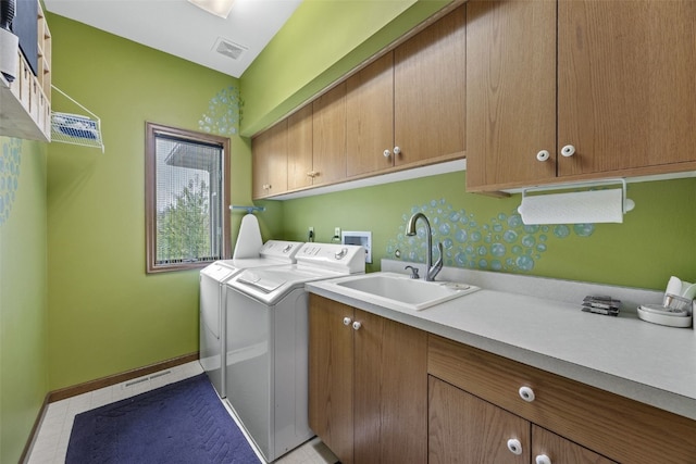 laundry area with cabinet space, independent washer and dryer, a sink, baseboards, and visible vents
