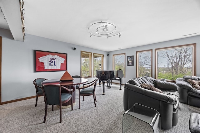 dining room featuring baseboards and light carpet