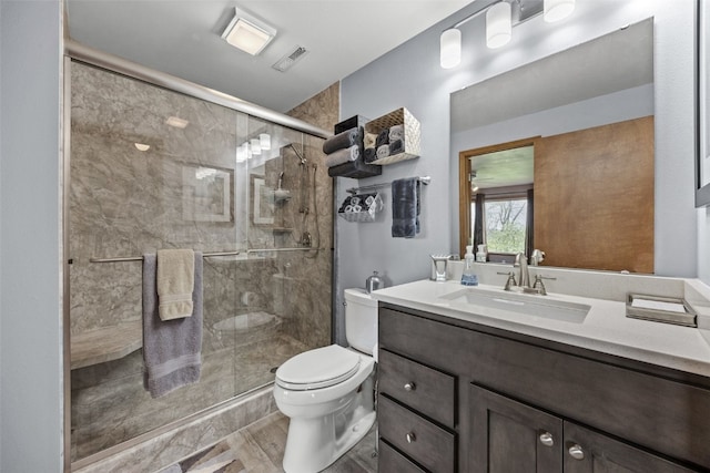 bathroom featuring vanity, visible vents, toilet, and a shower stall