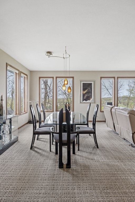 carpeted dining space with baseboards