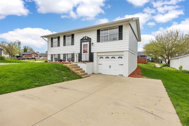 raised ranch with brick siding, a garage, a front lawn, and concrete driveway
