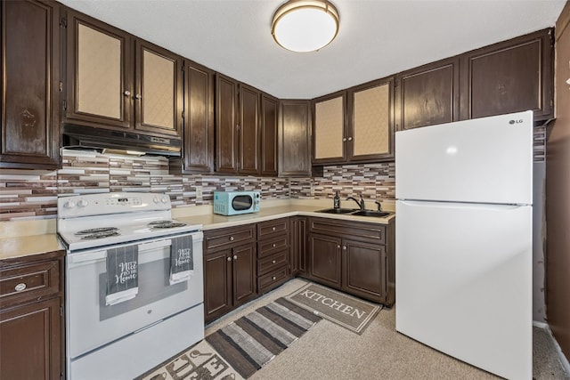 kitchen with dark brown cabinets, a sink, white appliances, light countertops, and under cabinet range hood