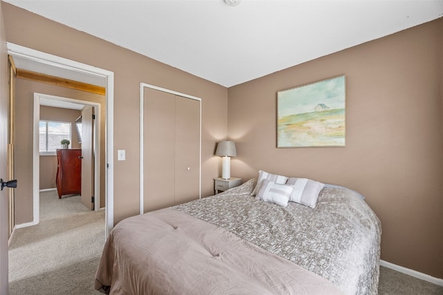 bedroom with carpet floors, baseboards, and a closet