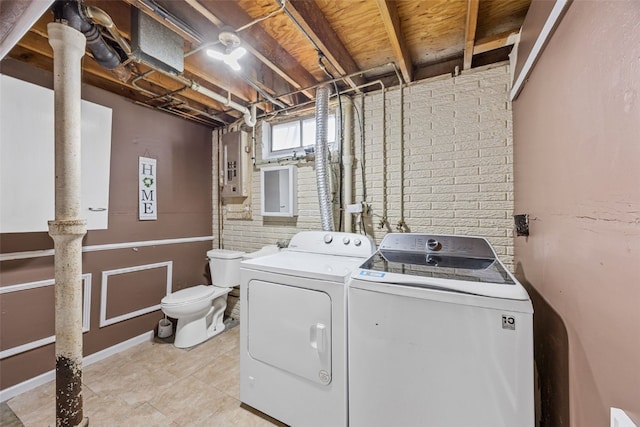 washroom with laundry area, electric panel, light tile patterned flooring, and washer and dryer