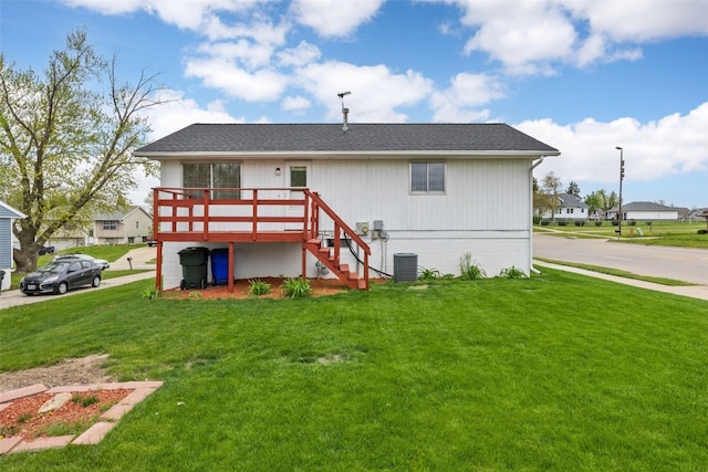 back of house with a lawn, a deck, central AC, and stairway