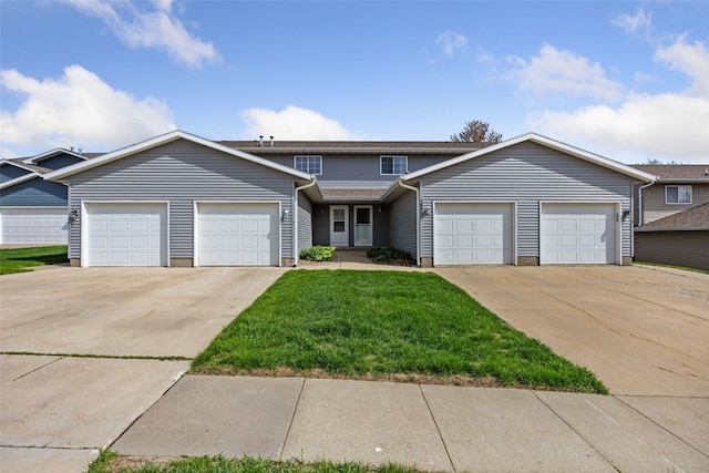 townhome / multi-family property featuring an attached garage, driveway, and a front yard