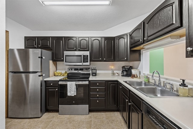 kitchen with a sink, appliances with stainless steel finishes, backsplash, and light countertops
