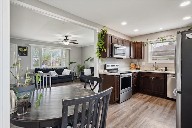 kitchen featuring light countertops, stainless steel appliances, a sink, and dark brown cabinets