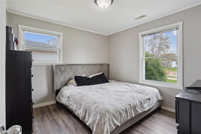 bedroom featuring multiple windows, wood finished floors, and visible vents