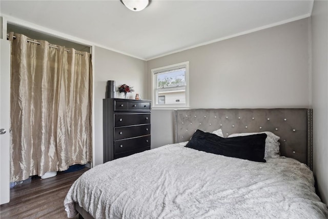 bedroom with ornamental molding and wood finished floors