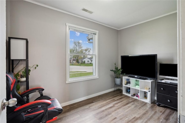 living area with crown molding, baseboards, wood finished floors, and visible vents