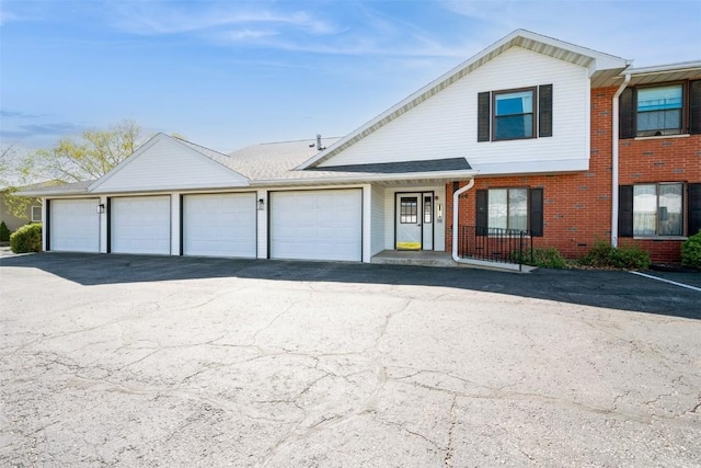 view of front of property with brick siding and aphalt driveway