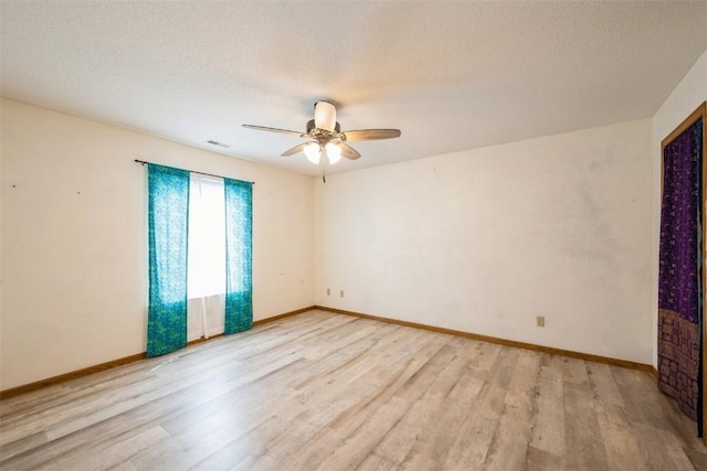 empty room with a ceiling fan, a textured ceiling, visible vents, and light wood-type flooring