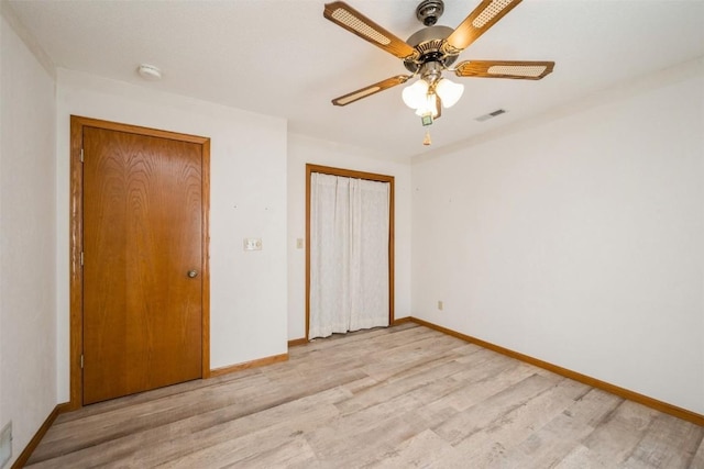 unfurnished bedroom with visible vents, light wood-style floors, baseboards, and a closet