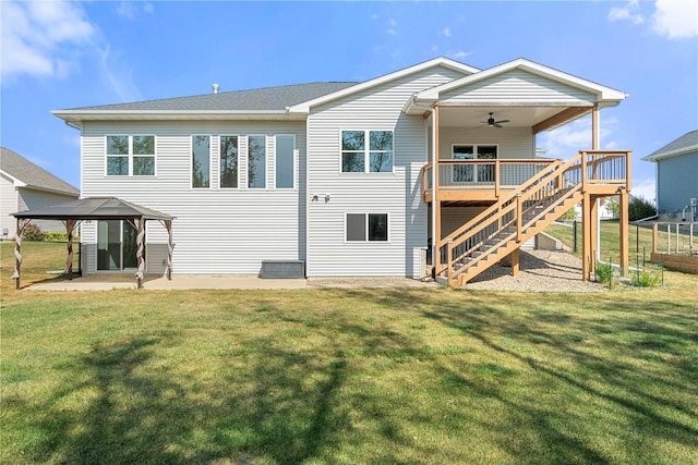 back of house with a lawn, a ceiling fan, a deck, and stairway