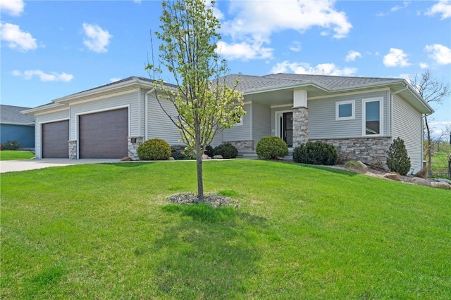 prairie-style home with a front yard, driveway, stone siding, and a garage