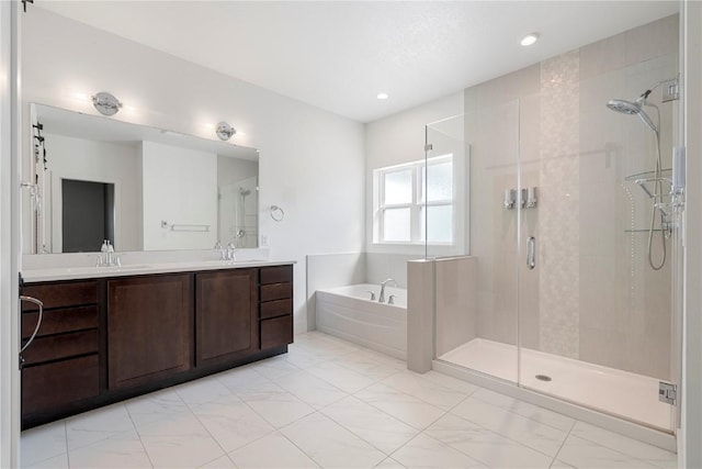 bathroom featuring a sink, double vanity, marble finish floor, a shower stall, and a bath