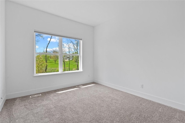carpeted spare room with baseboards and visible vents