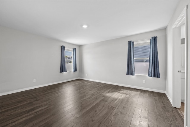 empty room featuring visible vents, recessed lighting, baseboards, and dark wood-style floors