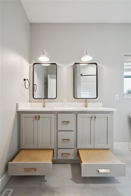 full bathroom with double vanity, visible vents, a sink, and tile patterned flooring
