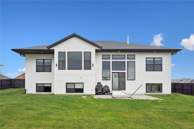 back of property featuring a patio area, fence, a yard, and roof with shingles