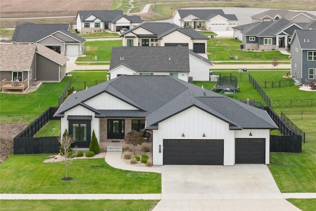 view of front of property featuring a residential view, fence, an attached garage, french doors, and driveway