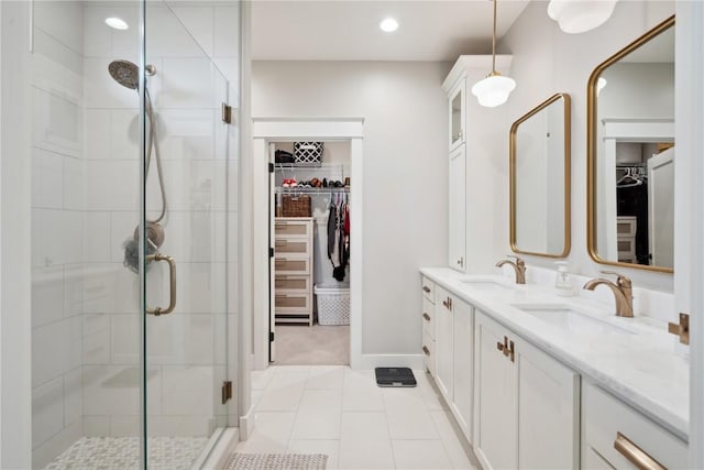 bathroom featuring double vanity, tile patterned floors, a shower stall, and a sink