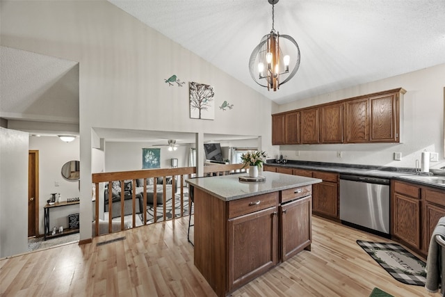 kitchen featuring a center island, stainless steel dishwasher, light wood finished floors, and decorative light fixtures