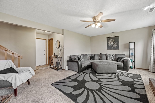 living area with a ceiling fan, a textured ceiling, and light colored carpet